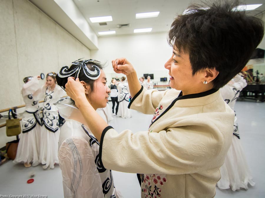 Photo by Mike Strong (KCDance.com) - Wang Hong-yun fixing hair piece on dancer in studio run