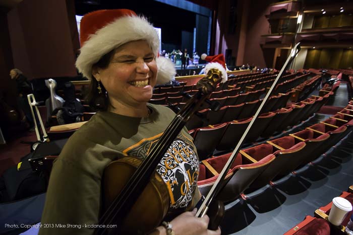 Photo by Mike Strong (kcdance.com) - Violinist Richelle Basgall rehearsing in Santa hat with a tiny Santa hat on the carved head at the end of her violin