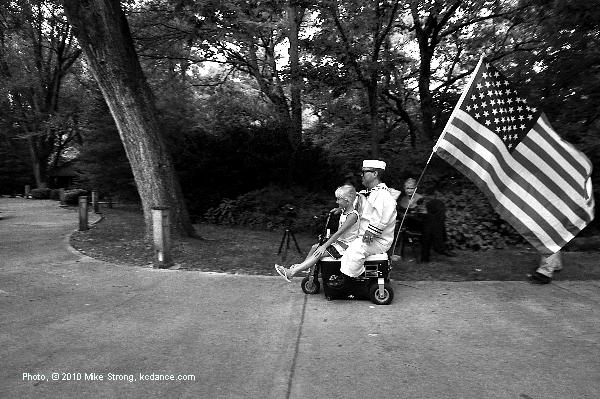 Jeff White riding a young fan on his Cooler-Scooter trailing a flag on the end - photo by Mike Strong kcdance.com